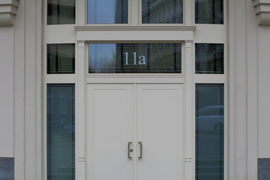white concrete building showing closed door with 11a print