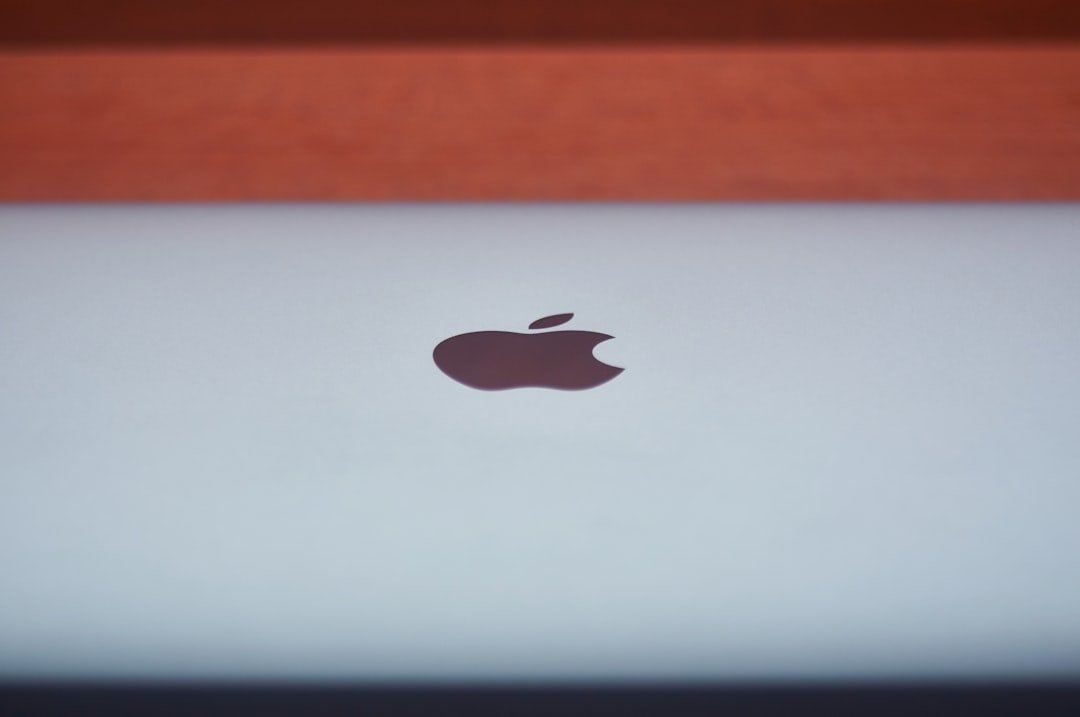 silver macbook on brown wooden table