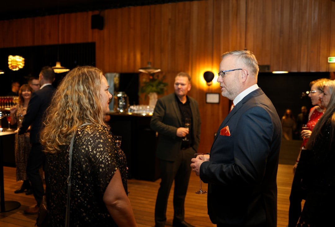 People mingling at a formal event with drinks