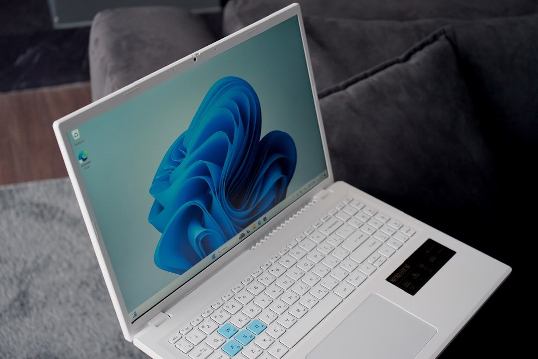 A white laptop with a blue windows 11 wallpaper.