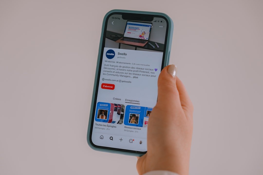 Hand holding a smartphone displaying a social media feed.